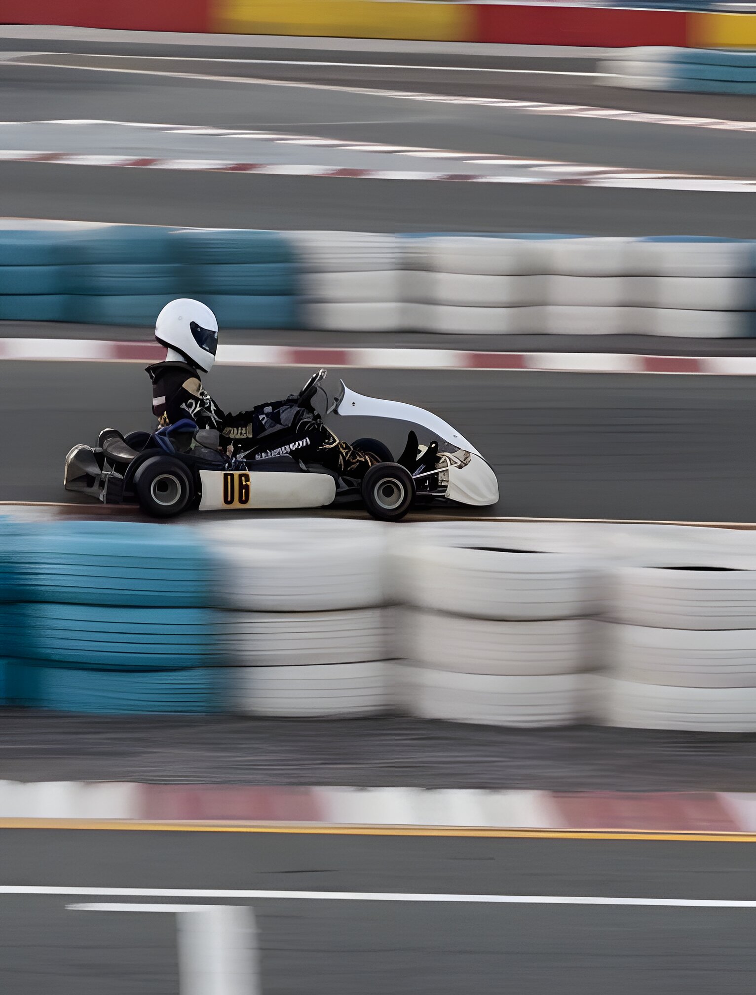 Full speed past the tyre wall, the background streaked into a blur