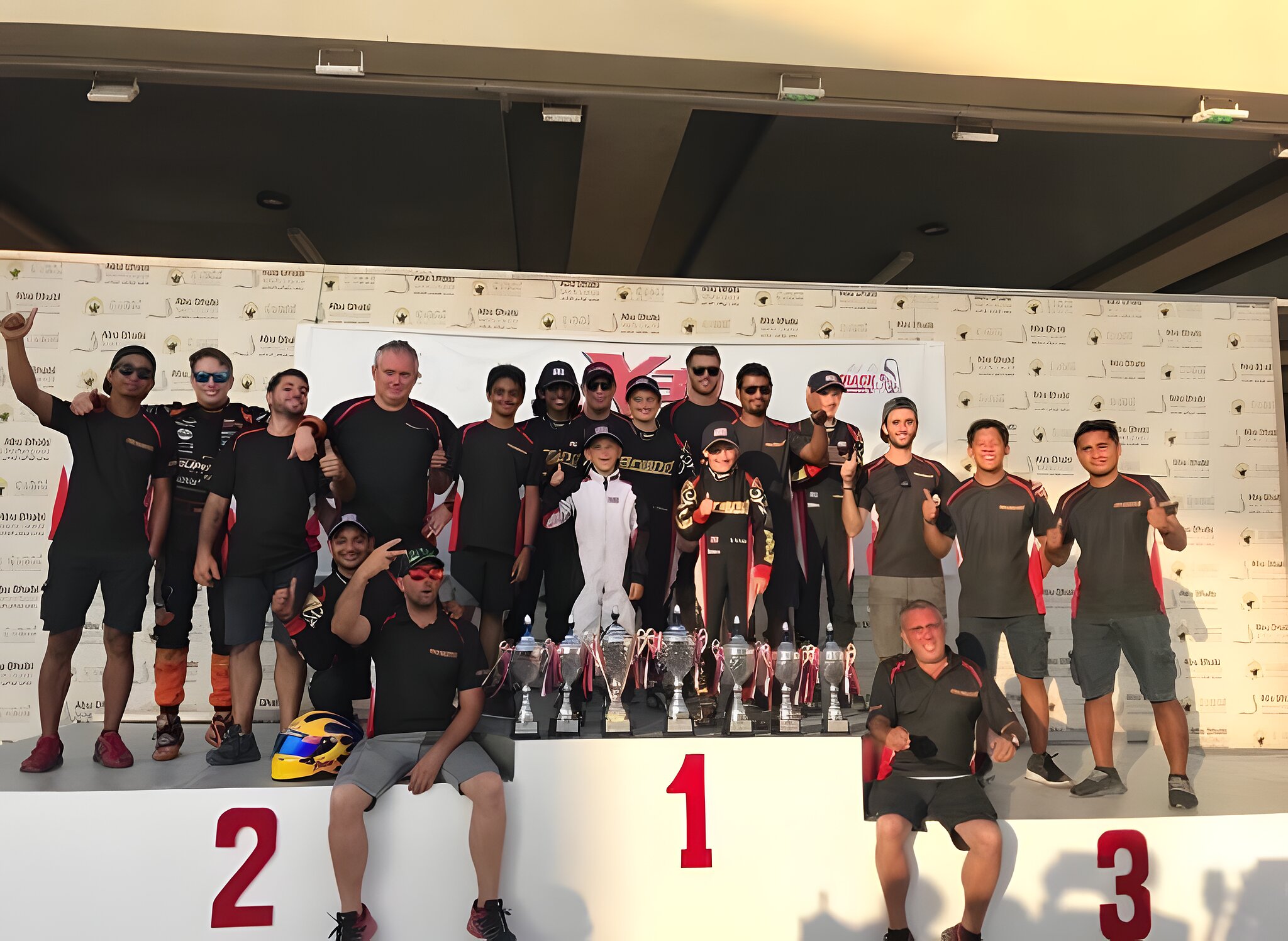 The whole team on the podium steps after a one-two-three