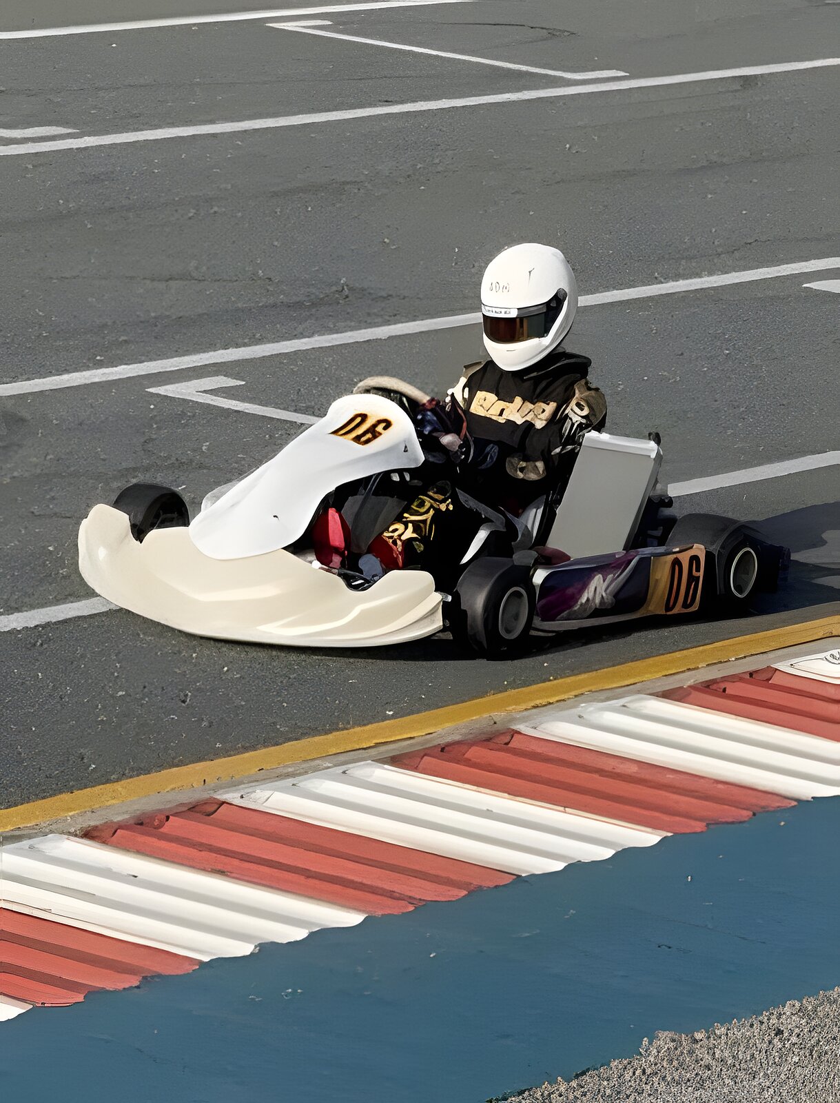 Zac in kart number 06, white helmet down, rolling past a red-and-white kerb